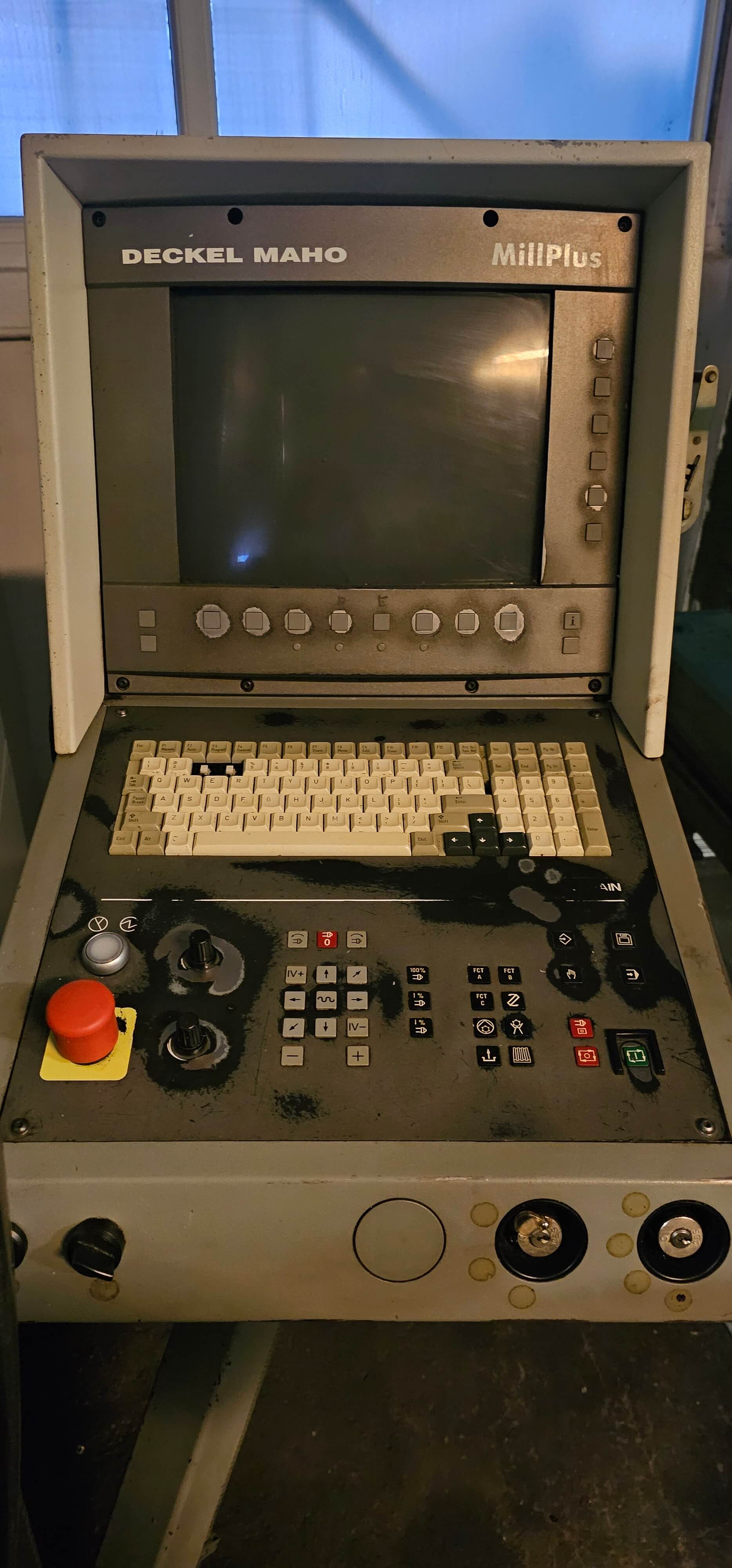 Nahaufnahme eines Bedienpanels der Deckel Maho MillPlus CNC-Maschine mit Bildschirm, Tastatur und Bedienknöpfen.